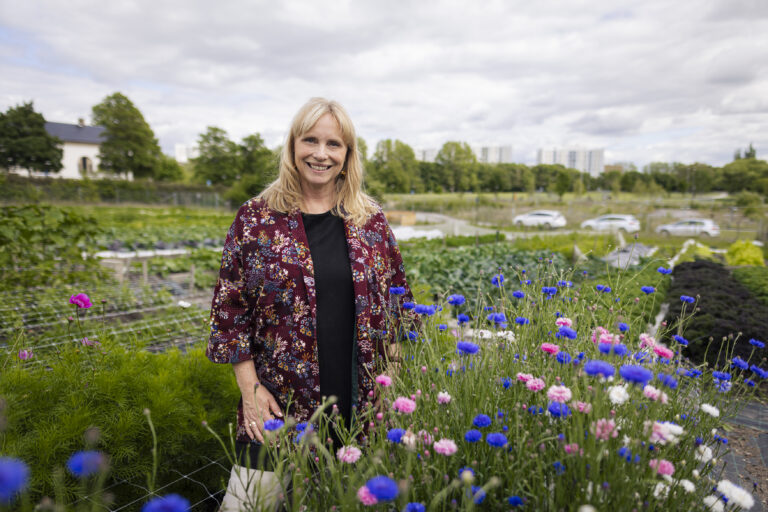 En kvinna som står i ett blomsterfält.
