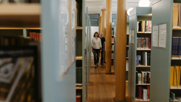 En man och en kvinna går igenom ett bibliotek