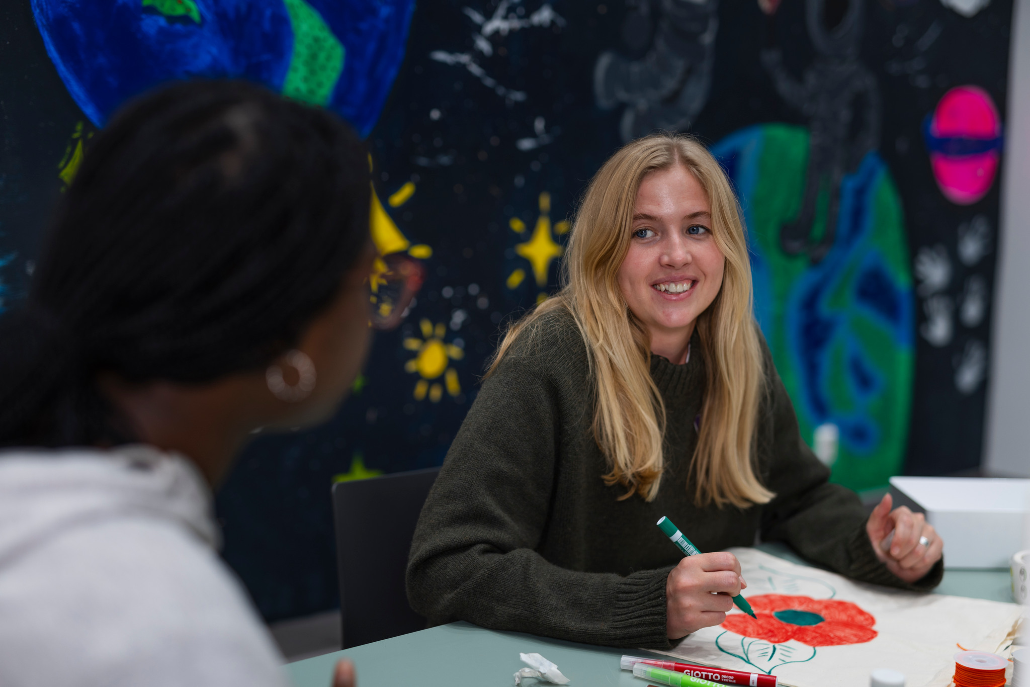 En kvinna sitter vid ett bord med ett barn.