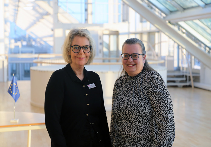 Två kvinnor inomhus i en ljusgård. Anneli Magnusson, ekonom och Katarina Wallgren, projektledare STEGA vidare Skövde kommun.