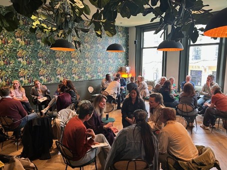 En grupp människor sitter runt olika bort och diskuterar
