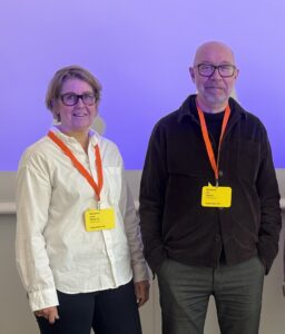 Två person står fram en vägg